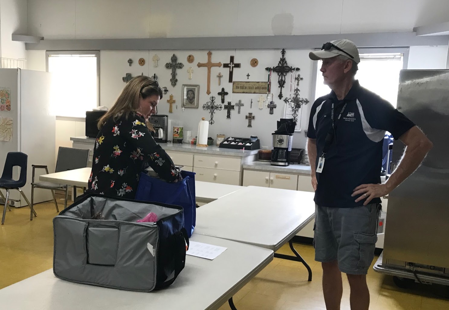 Commissioner Emily Lindley (left), a long time volunteer at Meals on Wheels, loads her cooler with meals for her route.
