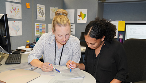 Jenna Kieschnick and fellow intern Tiara Kincade discuss both data and report information.