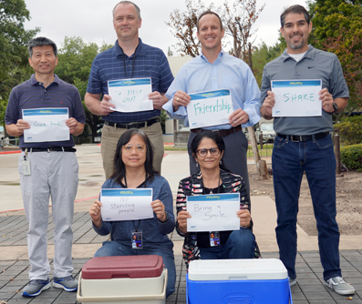 Thursday volunteers hold up their reasons for giving their time. Left to right-back row: Chuhua Tian, Erik Underkofler, Chance Goodin, and William Lara; front row: Candice Wong and Kanchan Raina.