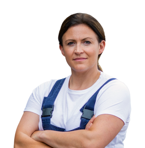 Woman in overalls crossing her arms.