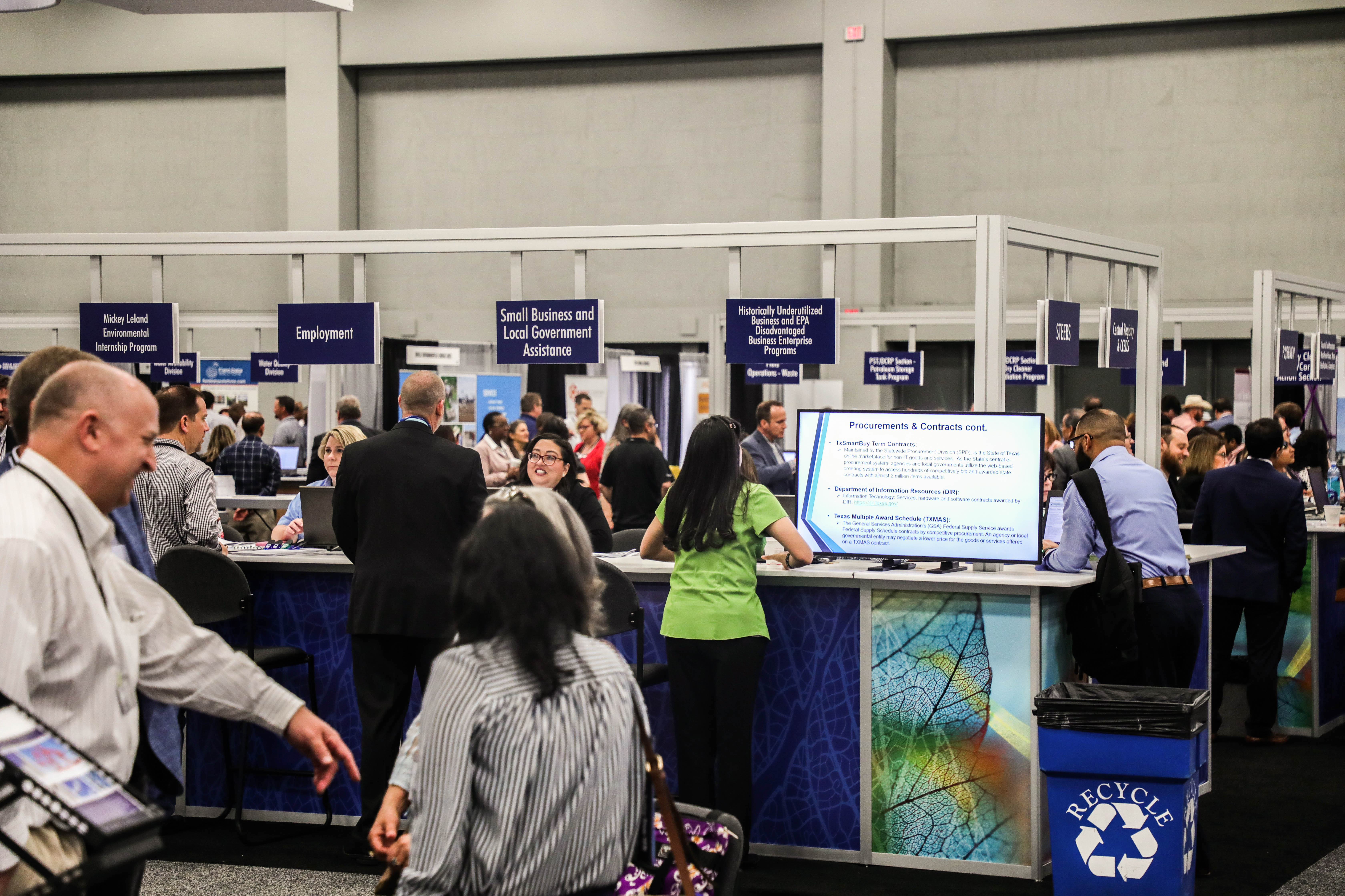A picture showing TCEQ employees and conference attendees at TCEQ's booth in the Exhibit Hall of the Convention Center.