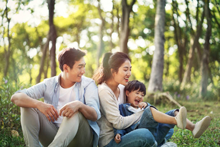 A family sitting together in a wooded area