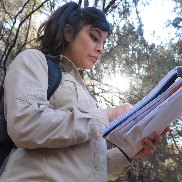 A woman examining documents out in the field